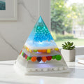 Resin Pyramid Lamp - pyramid-shaped lamp with embedded sweets and LED lights on a white surface.