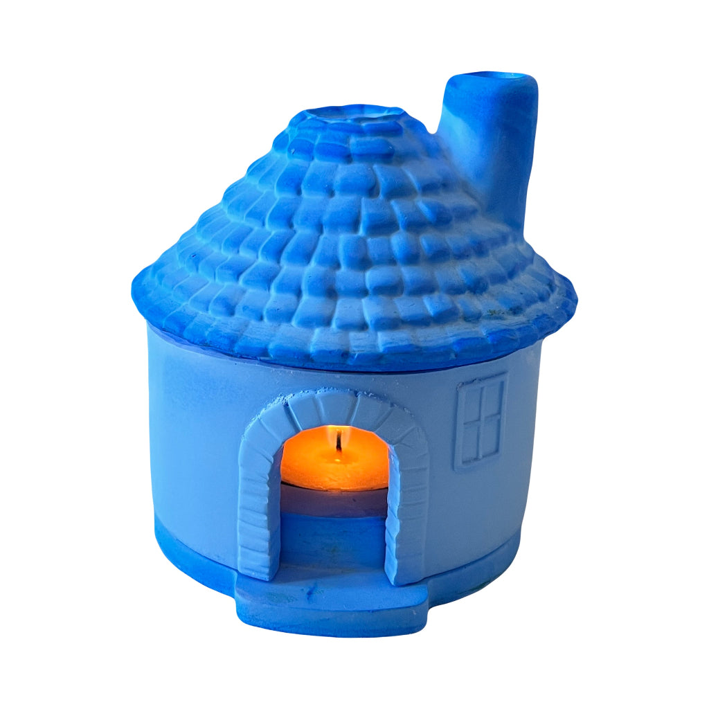 Candle Holder Houses - A small blue house-shaped candle holder with a lit yellow candle inside, on a white background