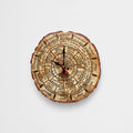 Celtic Calendar Clock A circular wall clock designed to look like a natural tree log slice, featuring astrological and zodiac symbols and text. The clock has black hands with red tips and is shown against a plain light gray background.