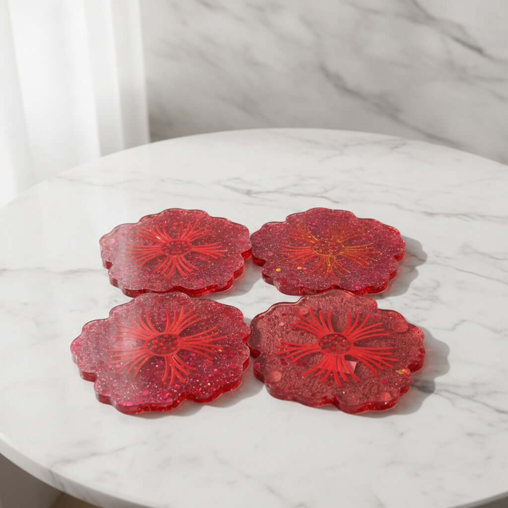 Flower shaped coasters - Four red glittery flower-shaped coasters arranged on a white marble table with a marble wall background.