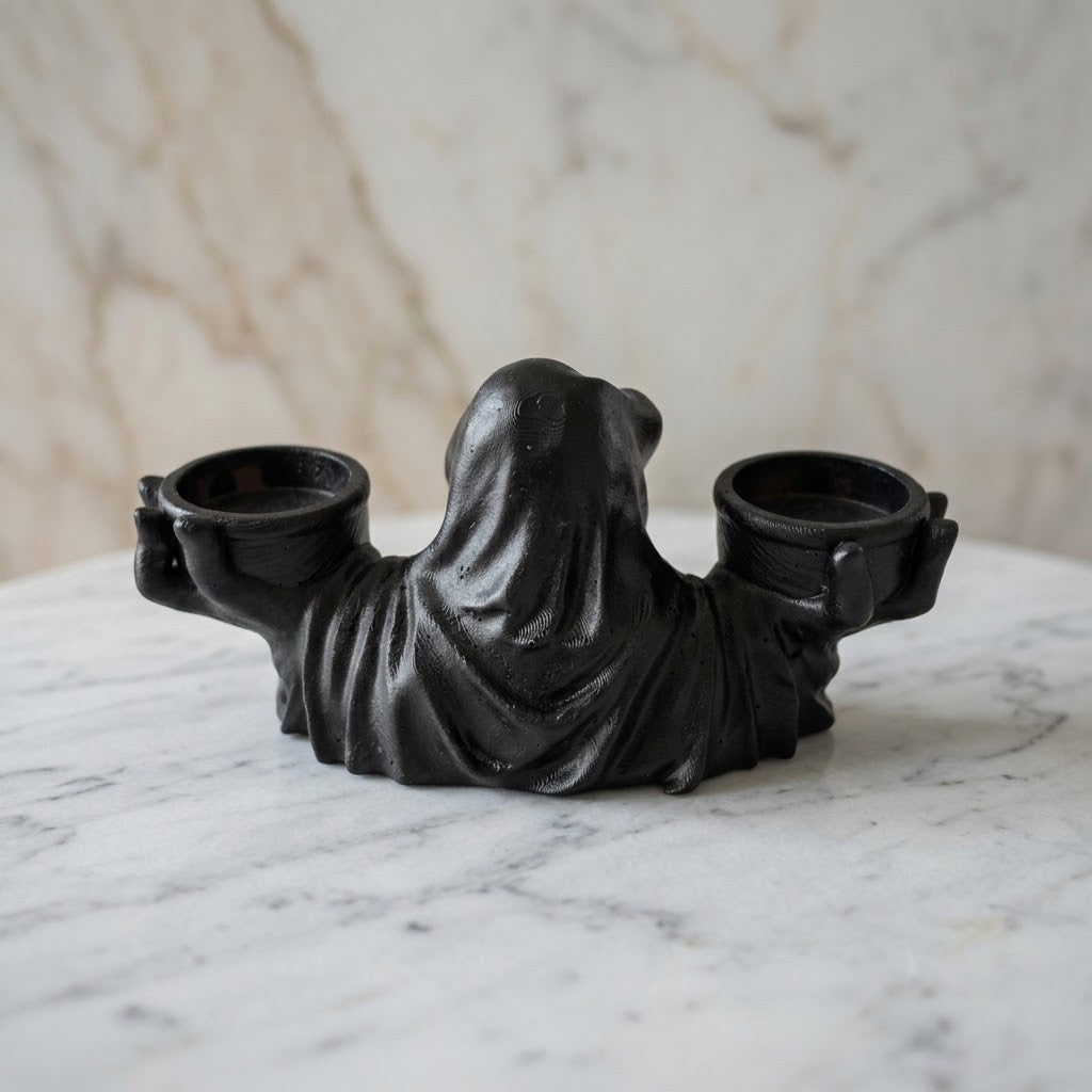 Grim Reaper Candle Holder - Back of a black resin double candle holder shaped like a draped hooded figure, set on a white marble surface with a matching marble background.