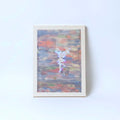 An unframed abstract art print featuring a silhouette of a dancing fairy figure against a textured background of blue, red, and orange brushstrokes, with small gold glitter accents, set against a plain white wall.